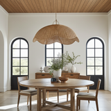 Dining room with wooden table, chairs, and a wicker rattan pendant light.