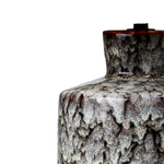 Close-up of a textured ceramic lamp with a rattan shade on a white background