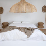 Bedroom with white bedding, oversized rattan chandelier 150 cm lampshade, UK
