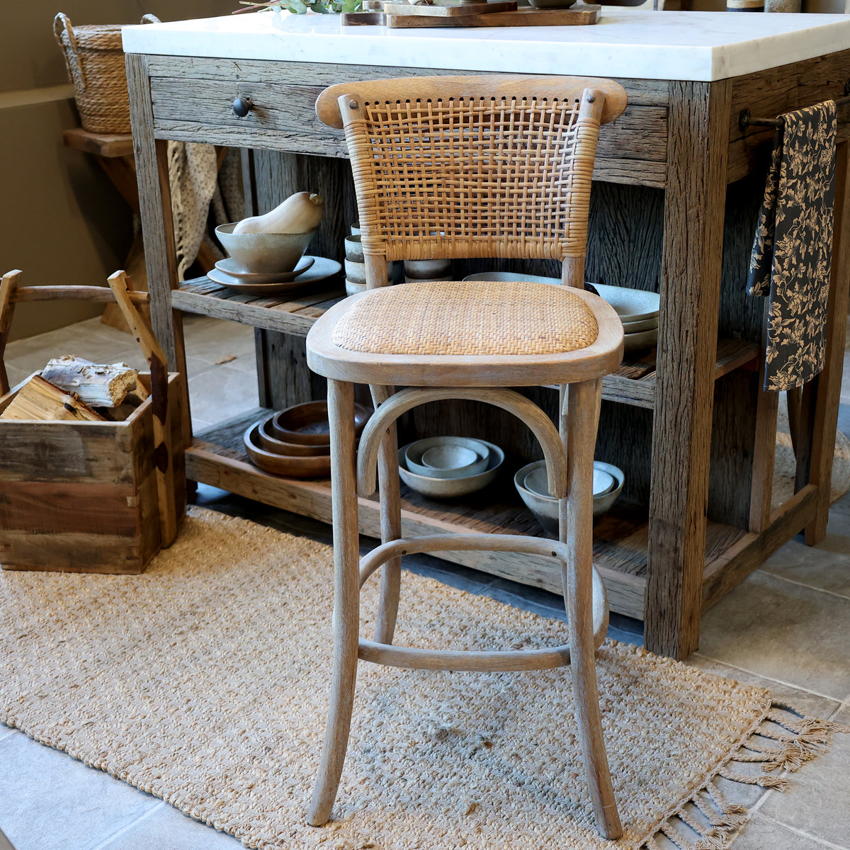 Wooden bar stool with wicker backrest in a rustic kitchen setting