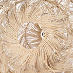 Close-up of a beige woven rattan  lampshade with a circular design.