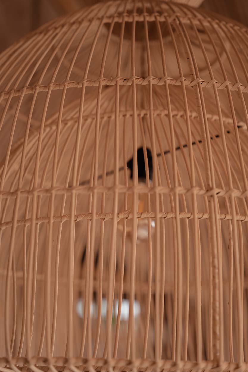 Close up of a woven rattan lampshade with a blurred background