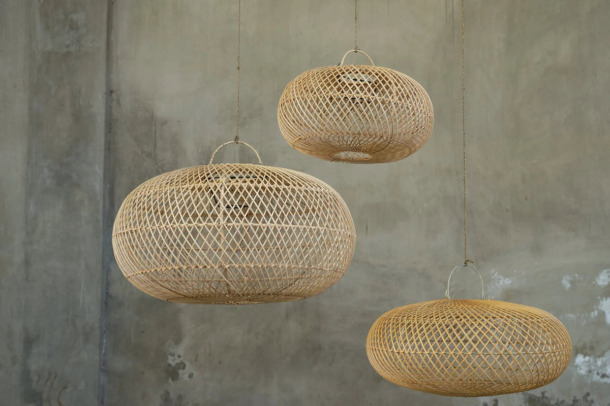 Three woven rattan pendant lights hanging against a textured wall.