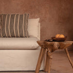 earthy plastered living room with beige linen sofa and teak coffee table