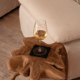 Wine glass on a wooden side table with a couch in the background