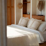 Bedroom with wooden shelves, natural cushions, rattan light, crochet bedspread