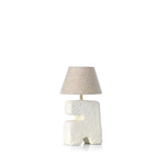 Table lamp with a textured base and beige lampshade on a white background