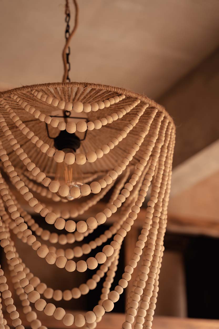 Close up of a beaded chandelier with a warm, beige background